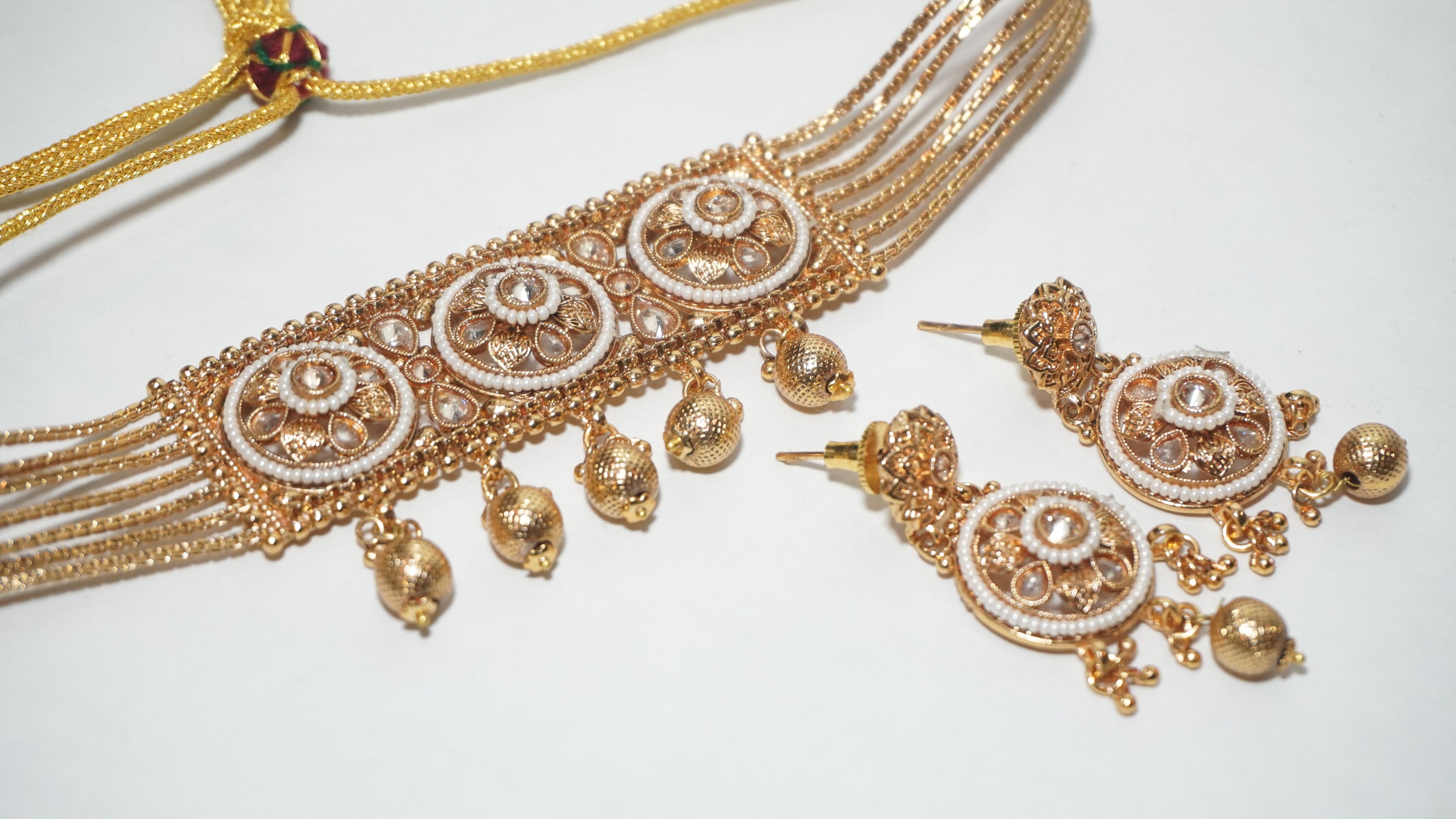 Traditional Antique Gold-Toned Multi-Strand Choker Set with Floral Centerpiece and Matching Jhumka-Style Earrings