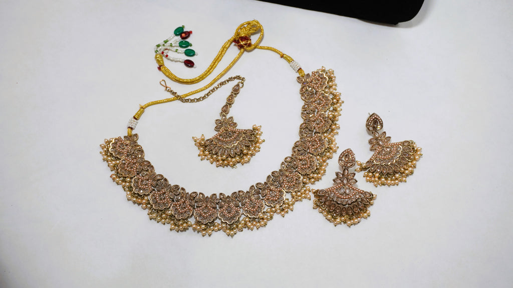 Antique Gold-Toned Floral Choker Set with Champagne Stone Accents, Matching Earrings, and Maang Tikka