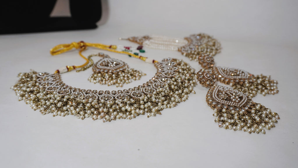 Regal Antique Gold-Toned Jewelry Set with Intricate Stonework, Maang Tikka, and Pearl-Fringed Passa