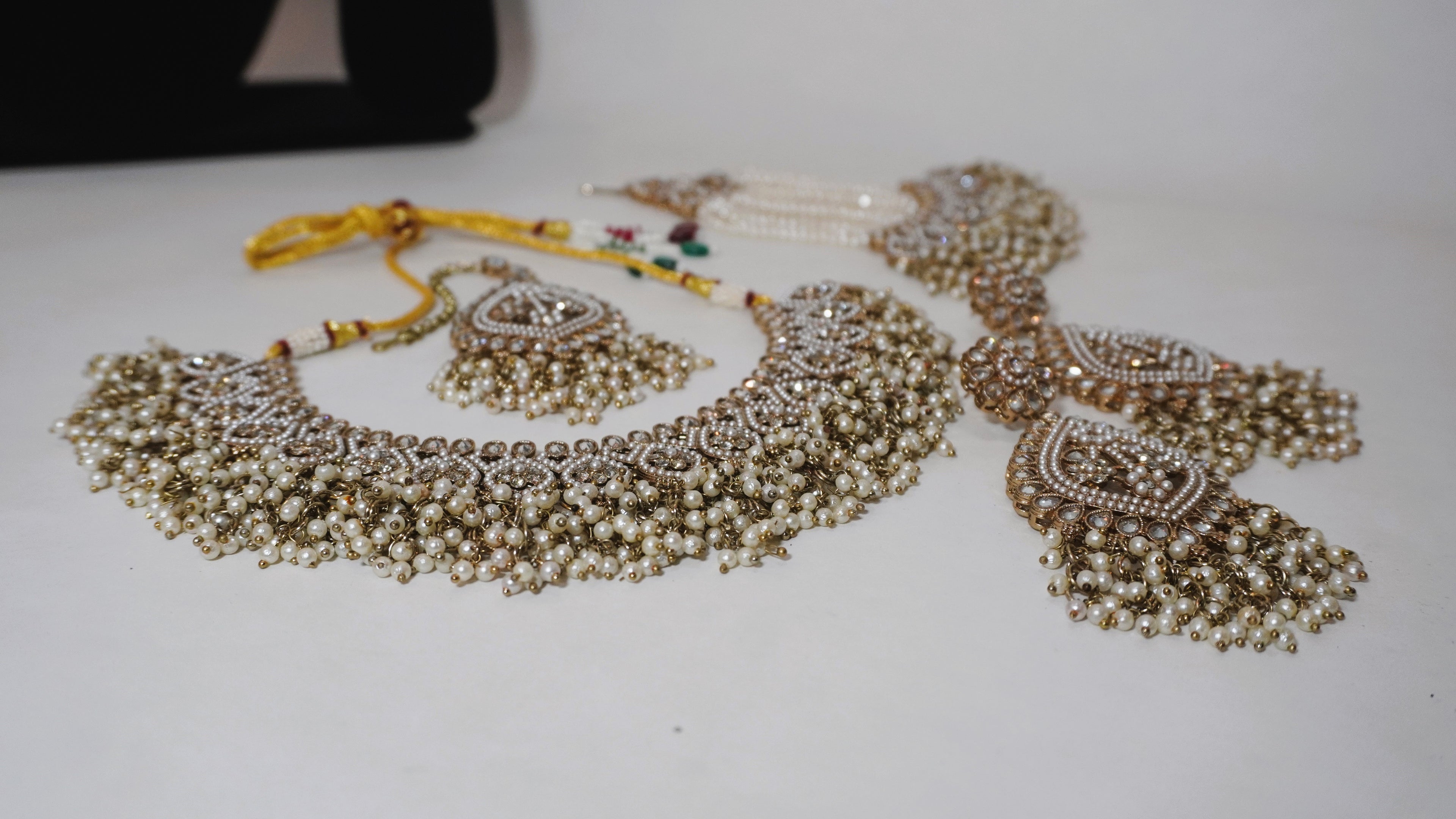 Regal Antique Gold-Toned Jewelry Set with Intricate Stonework, Maang Tikka, and Pearl-Fringed Passa