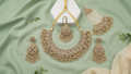 Regal Antique Gold-Toned Jewelry Set with Intricate Stonework, Maang Tikka, and Pearl-Fringed Passa